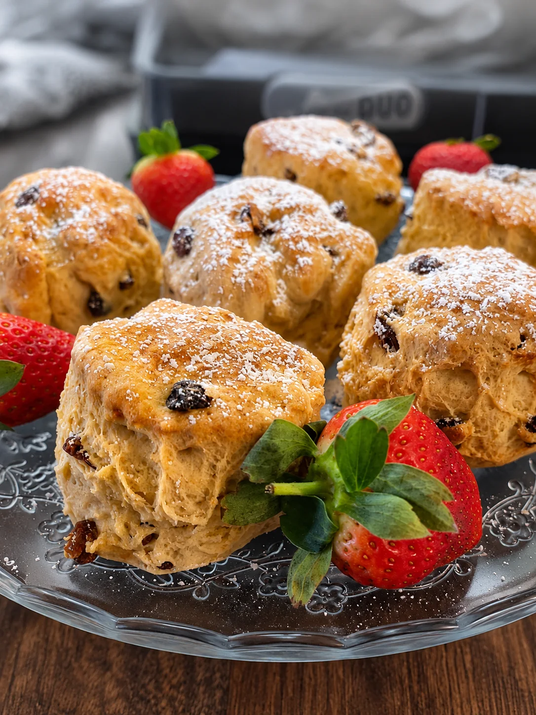 Freshly baked fruit scones on a glass plate